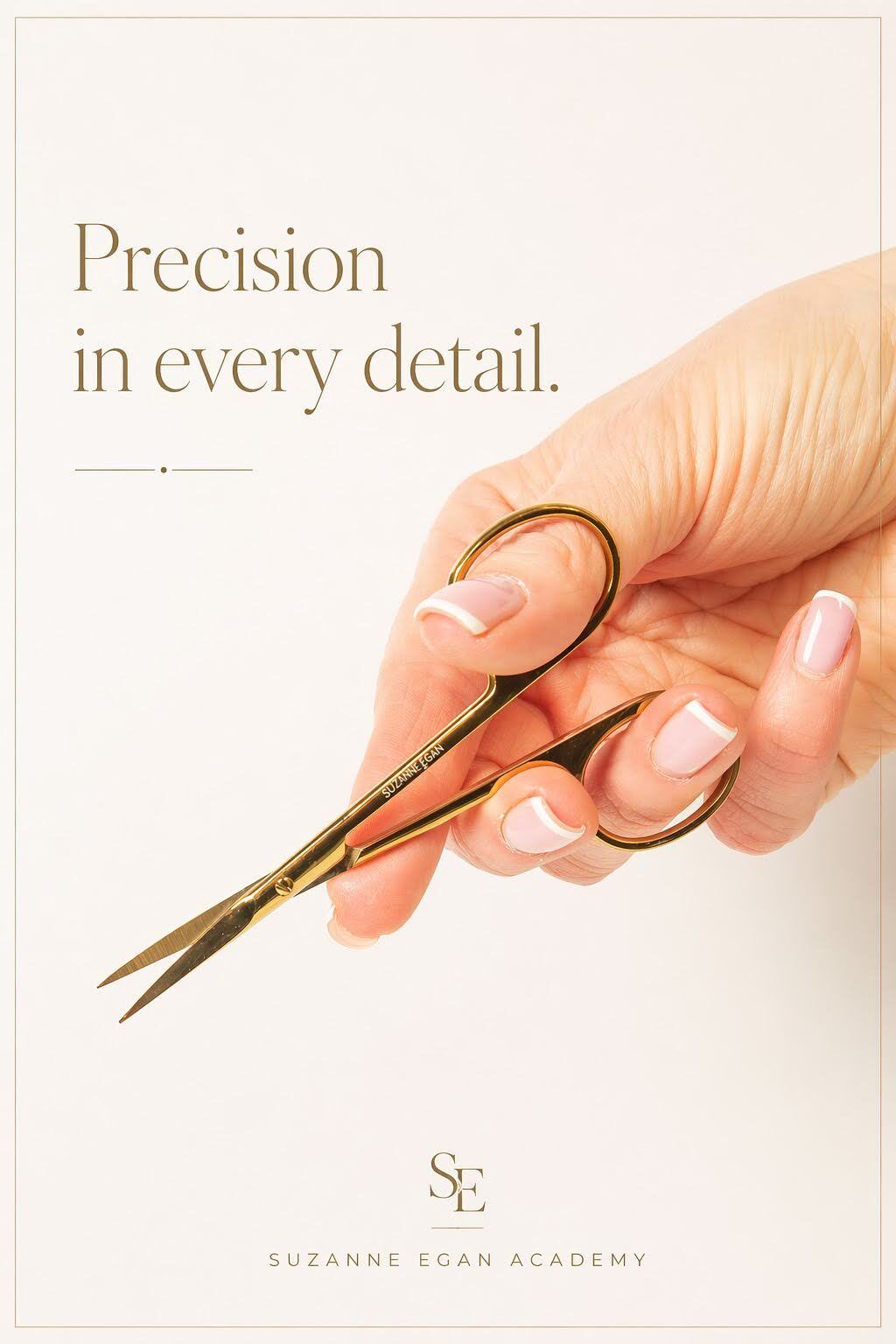 A hand holding small gold scissors, with the words "Precision in every detail"