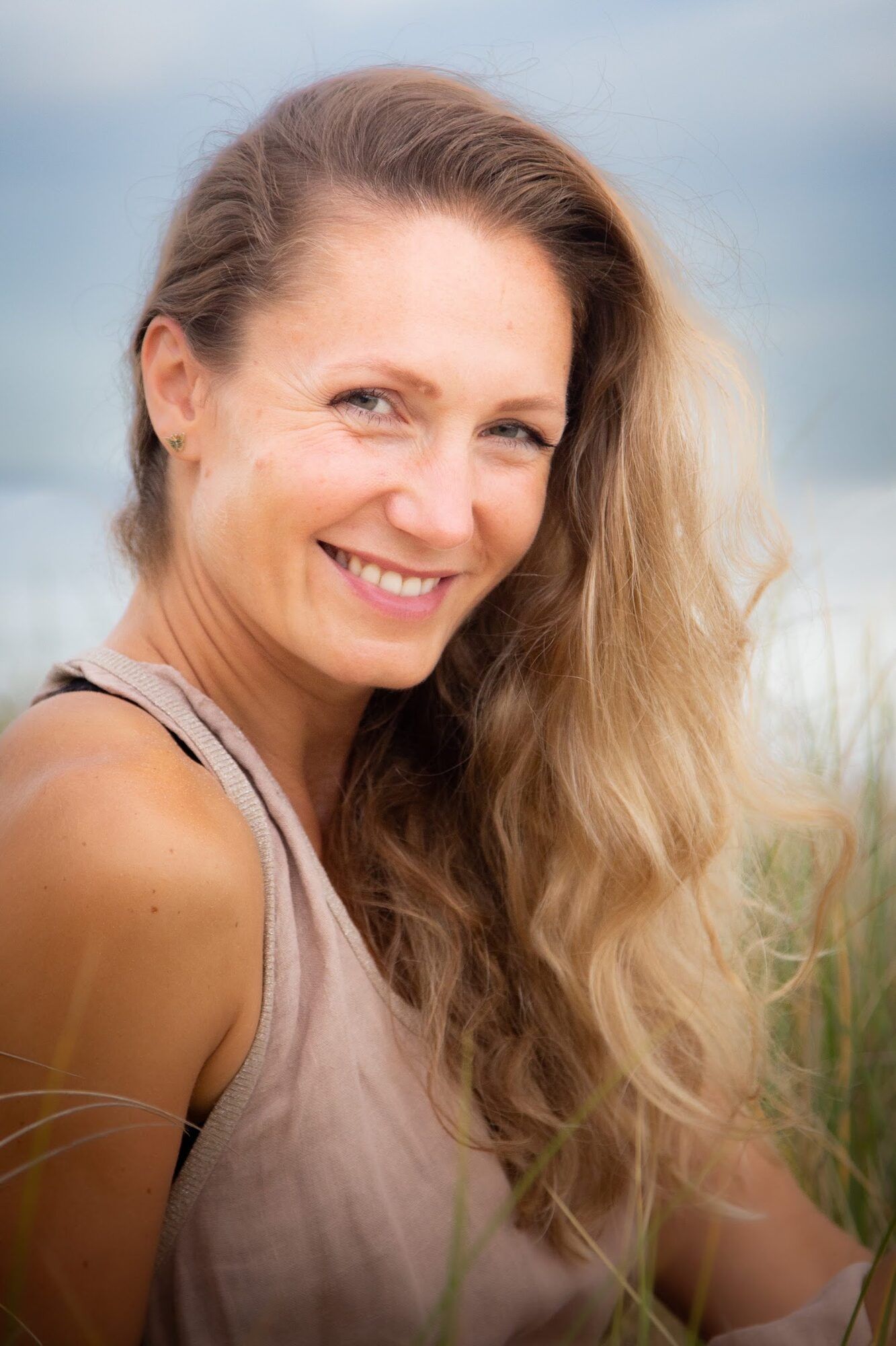 Woman with long wavy hair smiling outdoors