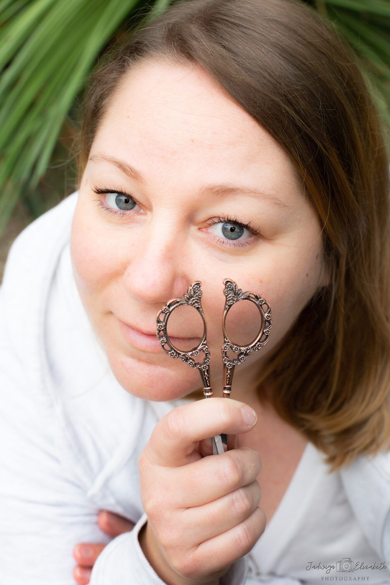 Woman holding vintage scissors to one eye