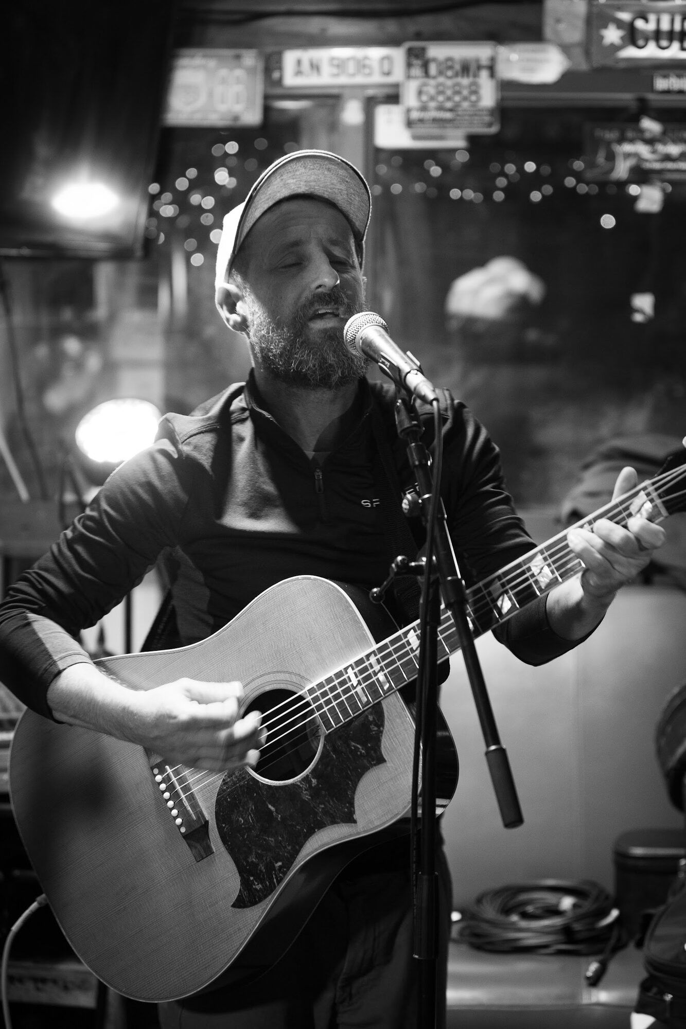 Czarno-białe: mężczyzna śpiewa z gitarą