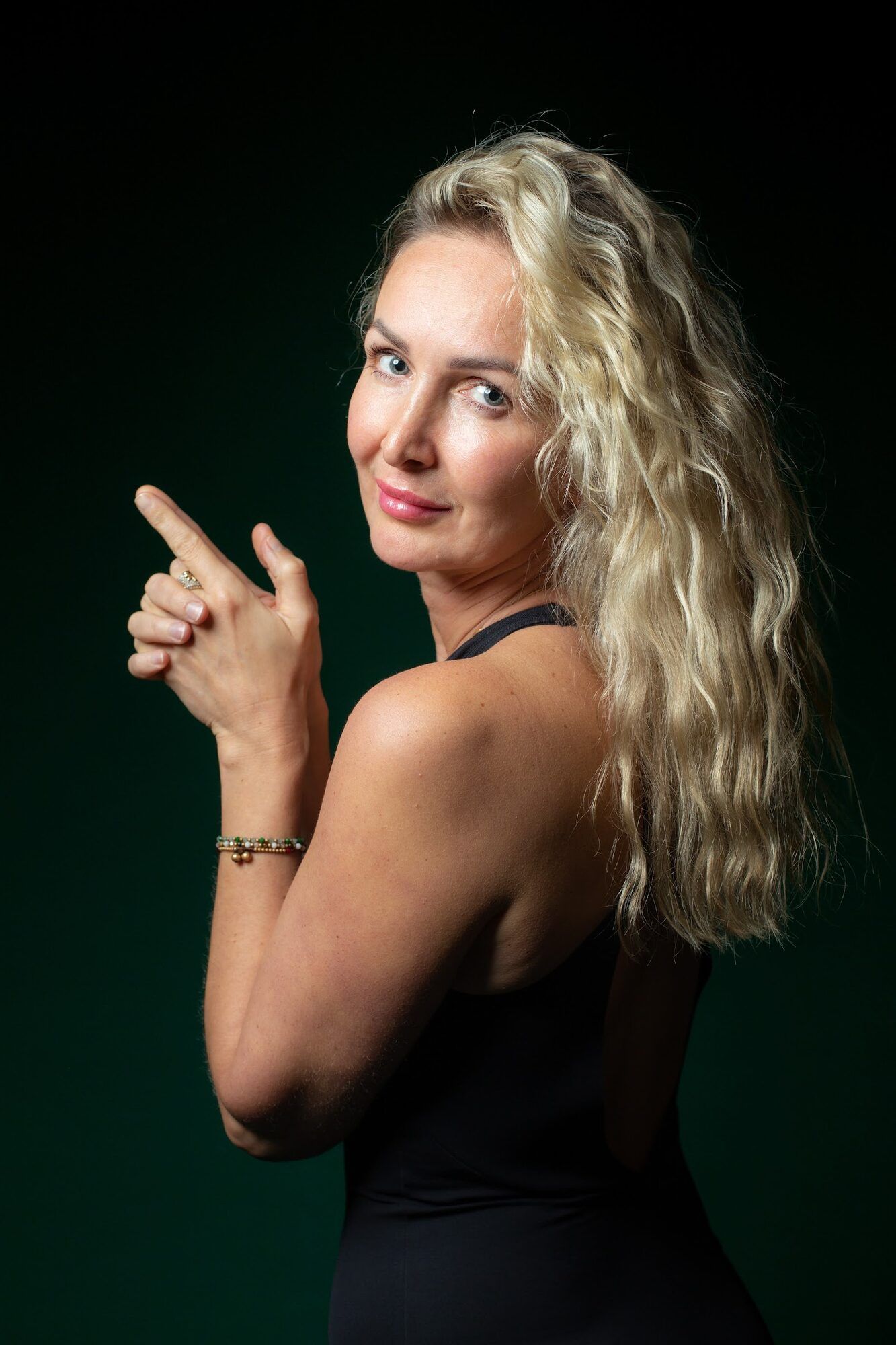 Blondynka patrzy przez ramię, zielone tło