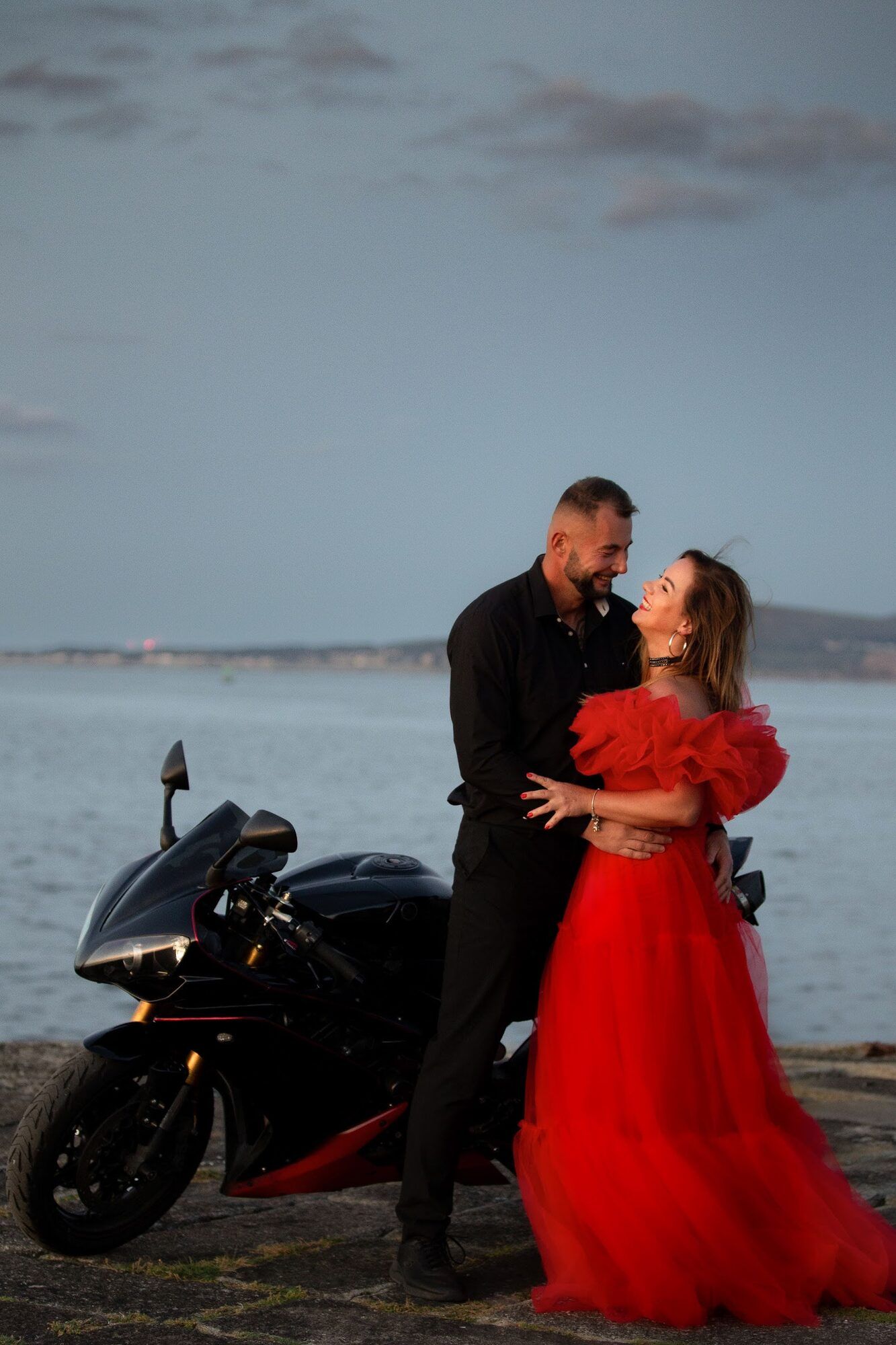 Para obok motocykla nad morzem